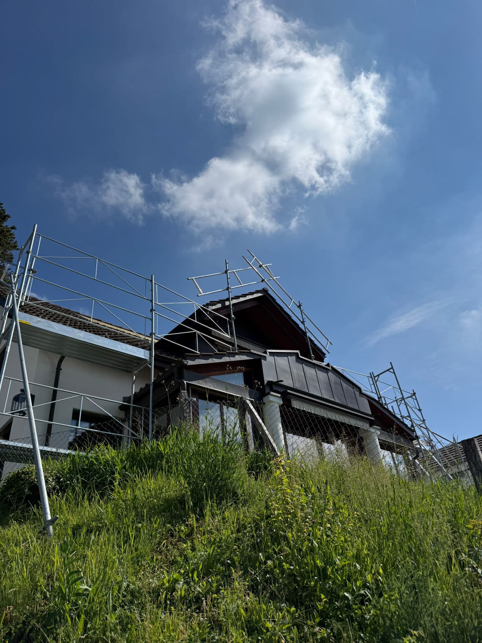 Schutzgerüst und Dachfang an einem Chalet-Dach während einer Dachsanierung in der Schweiz