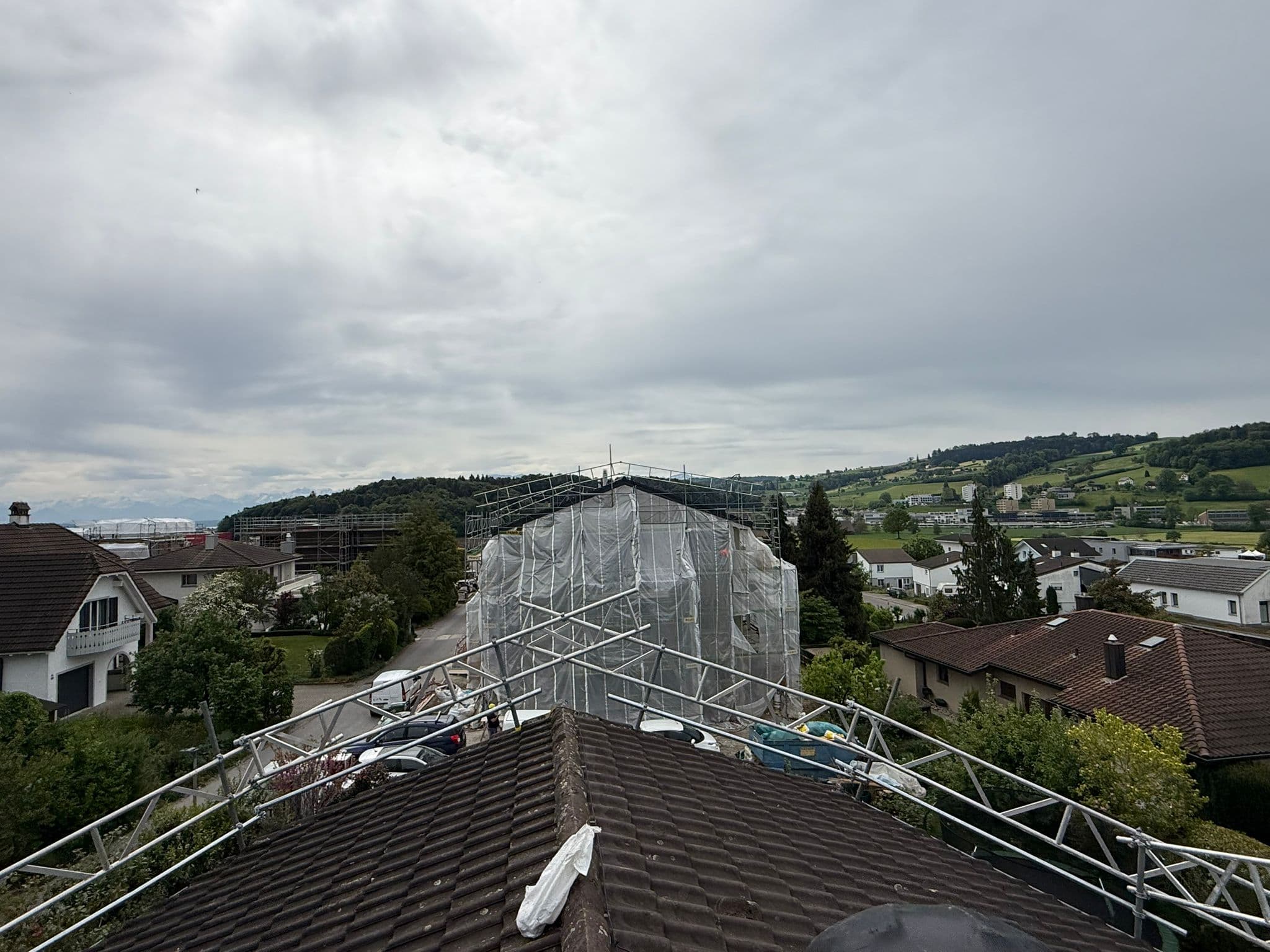 Dachfanggerüst der Elian Gerüstbau GmbH auf einem Dach mit Panoramablick über die Schweiz