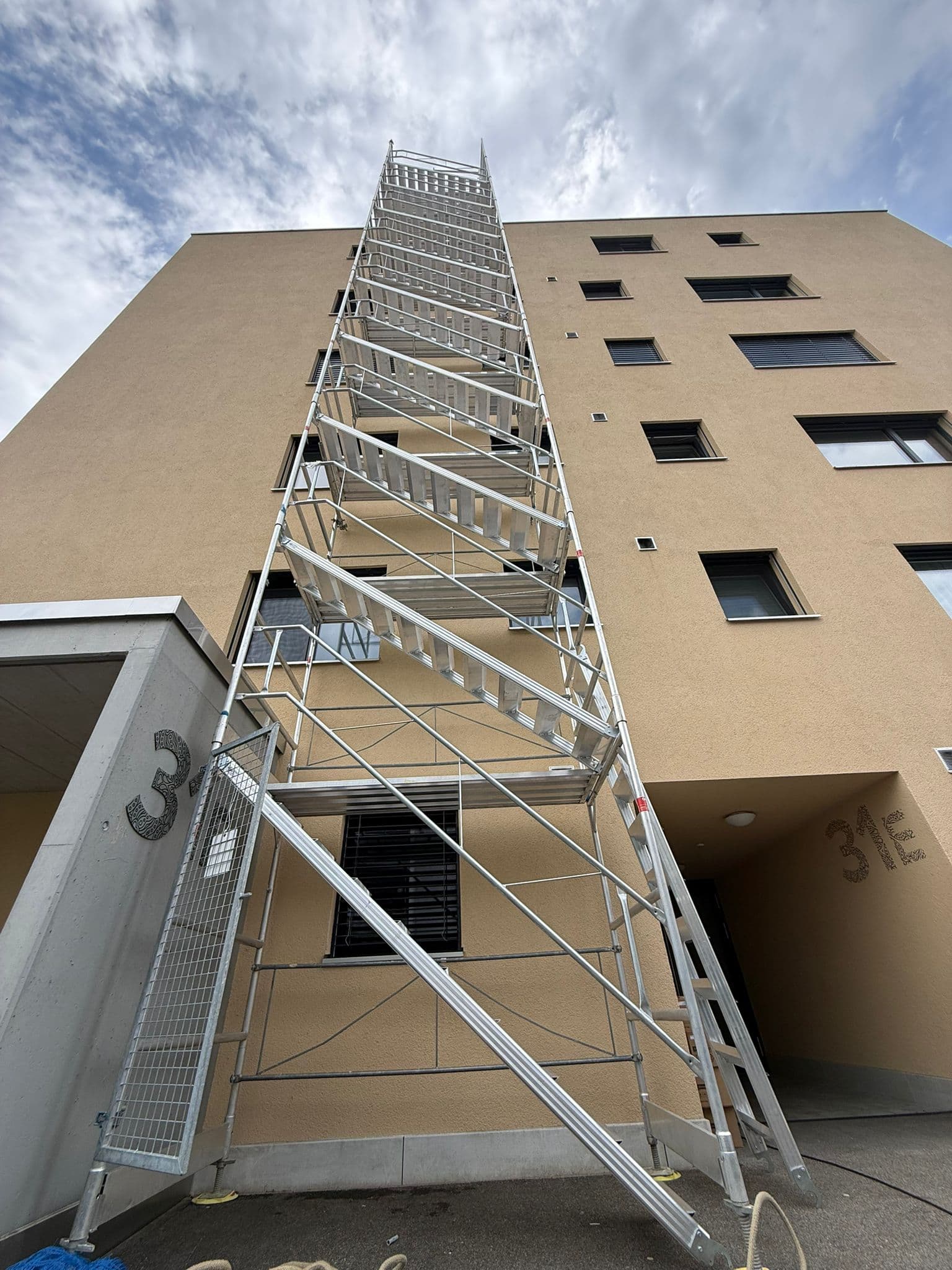 Hoher Treppenturm aus Modulgerüst der Elian Gerüstbau GmbH an einem Bauprojekt in der Schweiz